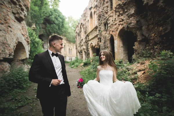 Bella coppia di sposi romantici che si abbracciano vicino al vecchio castello — Foto Stock