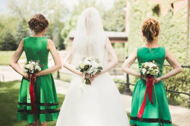 Gelin çiçekli büyük ve güzel bir düğün buketi tutuyor.