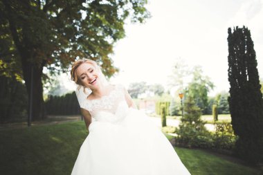 Gelinlik içinde dışarıda poz veren güzel gelin.