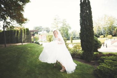 Gelinlik içinde dışarıda poz veren güzel gelin.