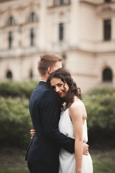 Casal de casamento bonito, noiva, noivo beijando e abraçando contra o fundo do teatro — Fotografia de Stock