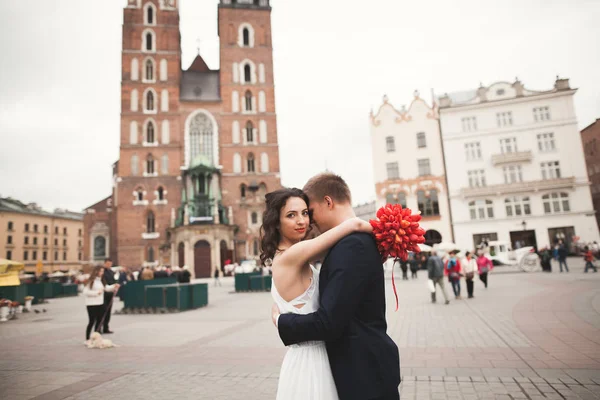 Elegant beautiful wedding couple walking on the main square in Krakow — Stock Photo, Image