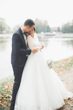 Yeni evli çift el ele tutuşurken parkta koşup zıplıyorlar.