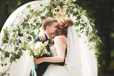 Yeni evli çift el ele tutuşurken parkta koşup zıplıyorlar.