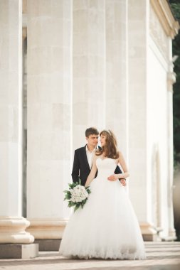 Güzel, mutlu bir düğün çifti, güzel şehirde uzun beyaz elbiseli bir gelin.