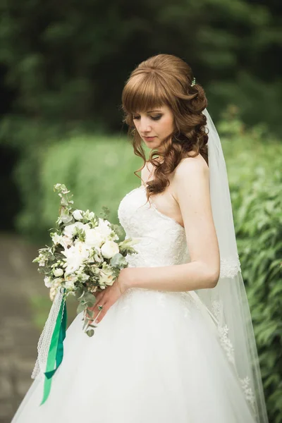 Ritratto di splendida sposa con capelli lunghi in posa con grande bouquet — Foto Stock