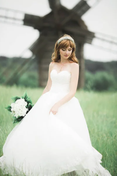 Портрет потрясающей невесты с длинными волосами, позирующей с большим букетом — стоковое фото