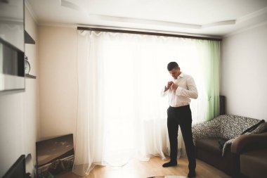 Güzel adam, damat poz veriyor ve düğüne hazırlanıyor.