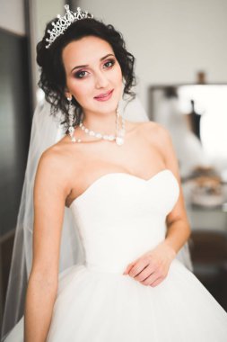 Beyaz elbiseli lüks gelin düğün törenine hazırlanırken poz veriyor.