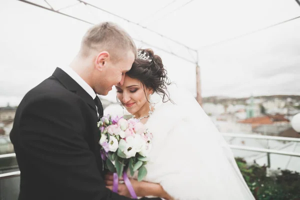 Bella coppia di nozze felice, sposa con abito lungo bianco in posa nella bella città — Foto Stock