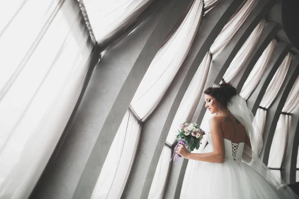 Porträt der atemberaubenden Braut mit langen Haaren posiert mit großem Strauß — Stockfoto