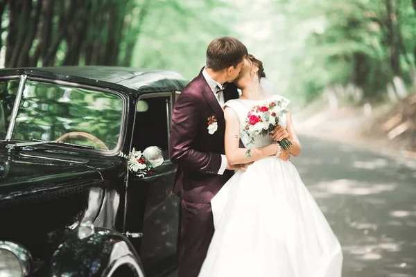 Κομψό ζευγάρι γάμου, νύφη, γαμπρός φιλιά και αγκαλιές σε ρετρό αυτοκίνητο — Φωτογραφία Αρχείου