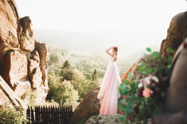 Gün batımında dağ zemin üzerine bir buket ile güzel gelin