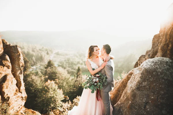 Hermosa pareja de boda besándose y abrazándose cerca de la montaña con vista perfecta — Foto de Stock