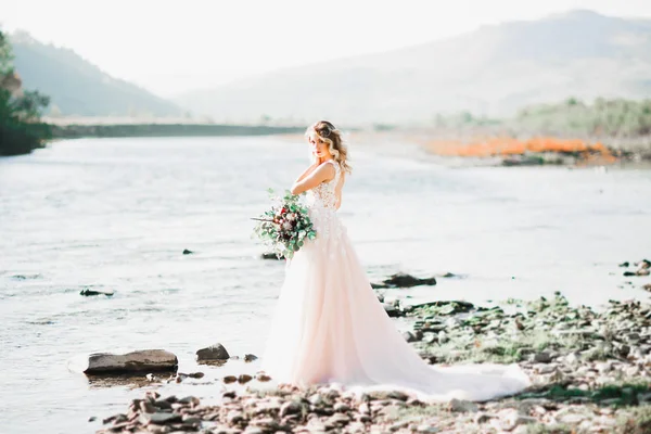 Ritratto di splendida sposa con lunghi capelli in piedi vicino al fiume — Foto Stock