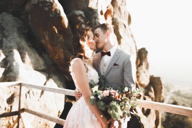 Gün batımında dağ zemin üzerine bir buket ile güzel gelin