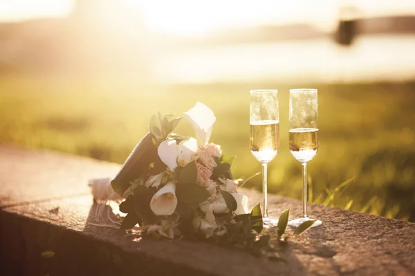 Bouquet da sposa e due bicchieri con champagne — Foto Stock