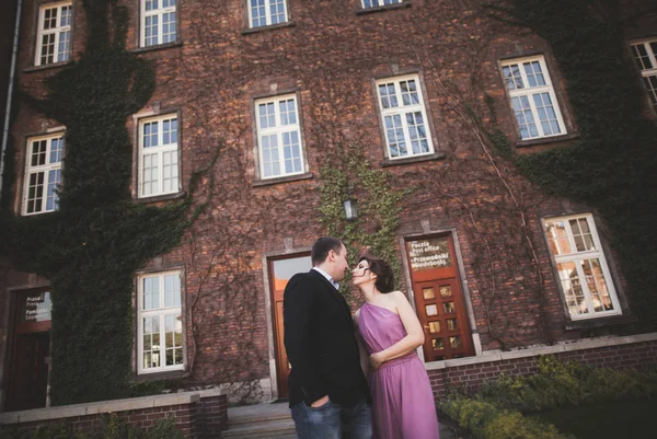 Young wedding couple in love story, bride and groom posing near building on the background. Krakow — Stock Photo, Image