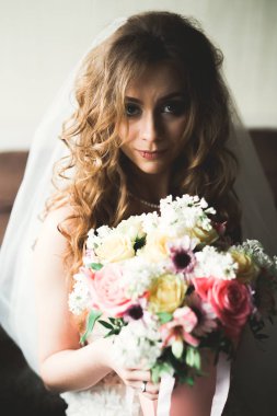 Beyaz elbiseli lüks gelin düğün törenine hazırlanırken poz veriyor.