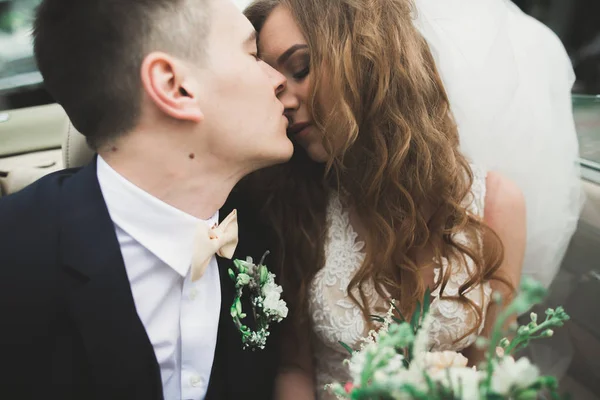 Apenas casal no carro retro de luxo em seu dia do casamento — Fotografia de Stock