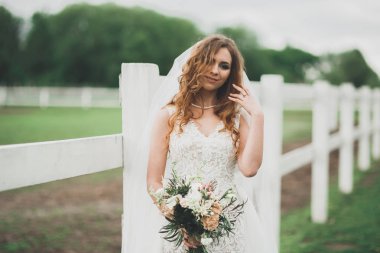 Gelinlik içinde dışarıda poz veren güzel gelin.