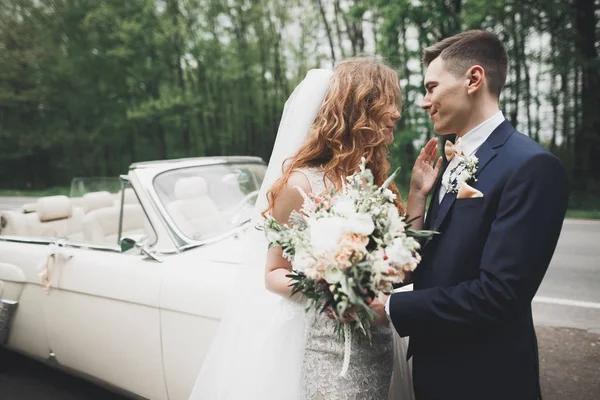 Elegante coppia di nozze, sposa, sposo baci e abbracci su auto retrò — Foto Stock