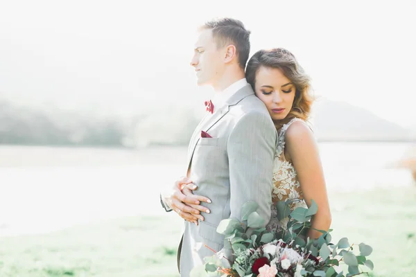 Perfect wedding couple holding luxury bouquet of flowers — Stock Photo, Image