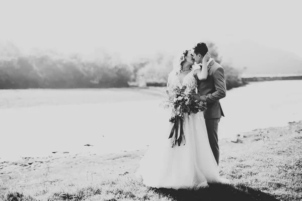 Hermosa pareja de boda, amor al atardecer. Fielf con flores — Foto de Stock