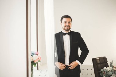 Güzel adam, damat poz veriyor ve düğüne hazırlanıyor.