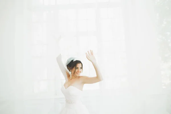 Bella sposa in abito da sposa con gonna lunga completa, sfondo bianco, danza e sorriso — Foto Stock