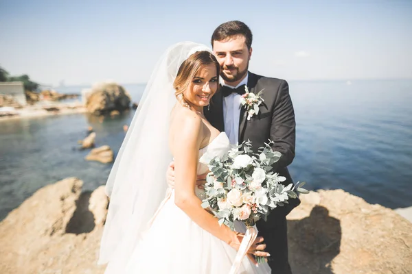 Scena felice e romantica di appena sposati giovani sposi in posa sulla bellissima spiaggia — Foto Stock