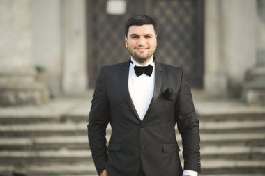 Arka plan eski kale üzerinde poz şık damat