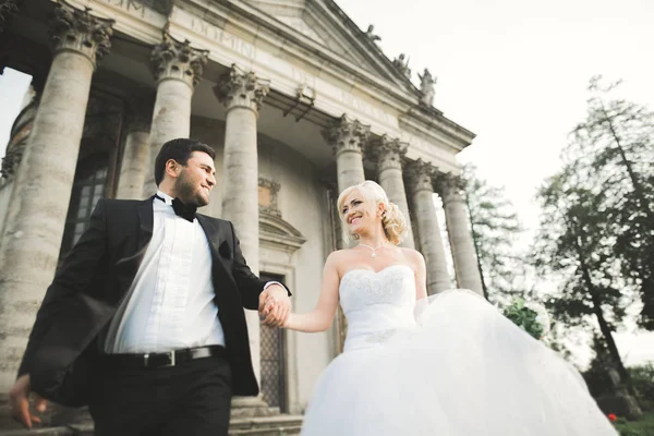 Lyckliga bröllop par kramas och kyssas på bakgrunden gamla slottet — Stockfoto