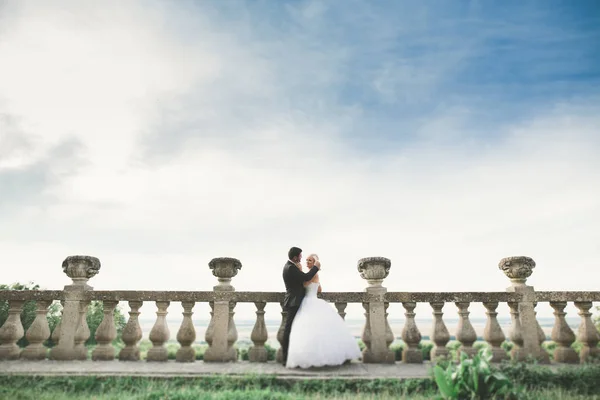 Felice matrimonio coppia abbracciare e baciare su sfondo vecchio castello — Foto Stock