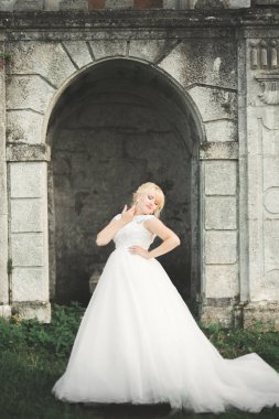 Parkta poz veren gelinlikli güzel, lüks bir gelin.