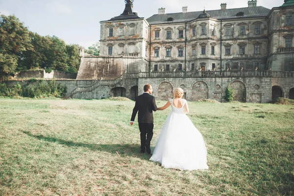 Bella coppia di sposi romantici che si abbracciano vicino al vecchio castello — Foto Stock