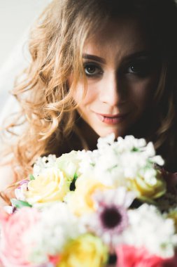 Beyaz elbiseli lüks gelin düğün törenine hazırlanırken poz veriyor.