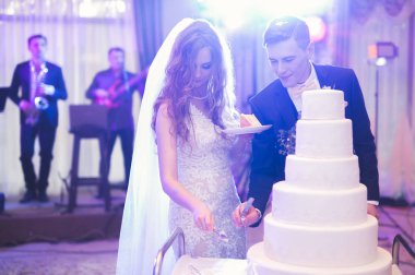 Gelin ve damat düğün pastasını kesiyor.