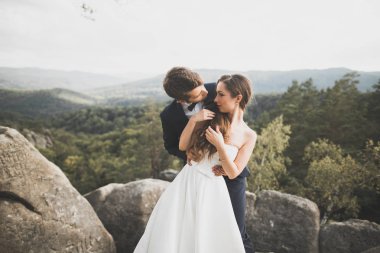 Muhteşem gelin, damat öpüşme ve sarılma Gösterim çarpıcı uçurum yakın: