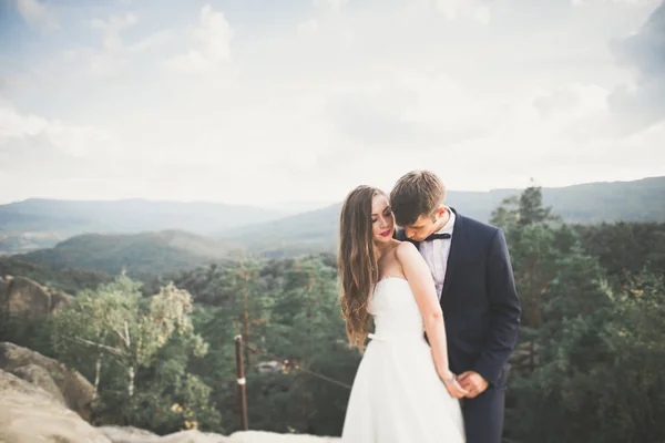 結婚式のカップルで愛キスと抱擁近くの岩で美しい風景 — ストック写真