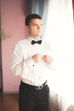 Güzel adam, damat poz veriyor ve düğüne hazırlanıyor.