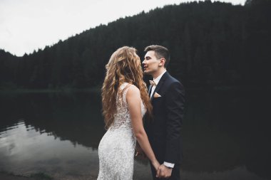 Harika bir gelin damada poz veriyor ve harika manzaralı dağlarda lüks bir tören yapıyor.