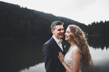 Harika bir gelin damada poz veriyor ve harika manzaralı dağlarda lüks bir tören yapıyor.