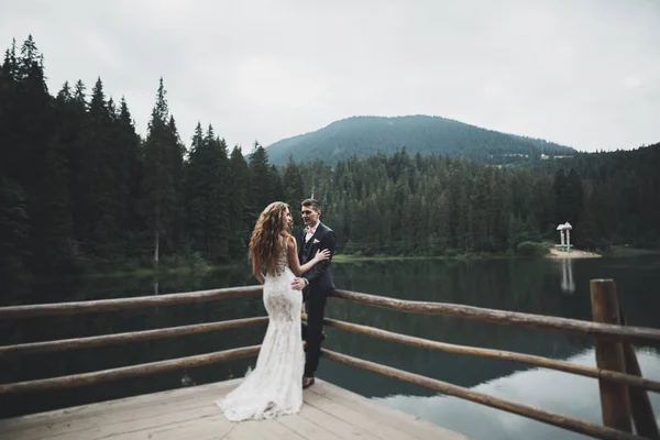 Coppia perfetta sposa, sposo posa e baci nel loro giorno del matrimonio — Foto Stock