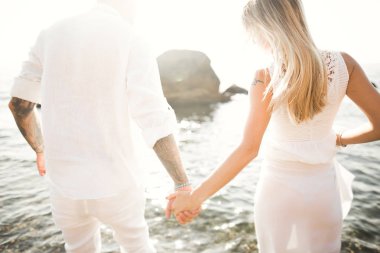 Gelin ve damat el ele tutuşuyor.