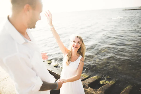 Hochzeitspaar küsst und umarmt sich auf Felsen nahe blauem Meer — Stockfoto