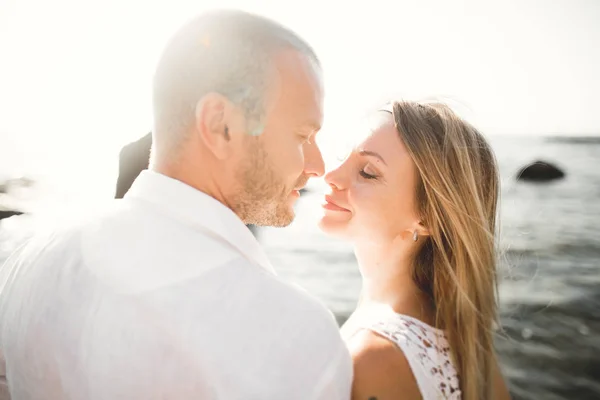 Щасливі щойно одружилися молода весільна пара святкує і розважається на красивому пляжному заході сонця — стокове фото
