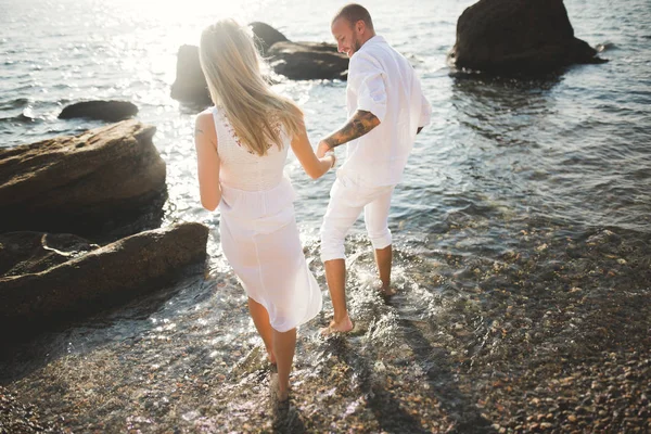 Απλά έγγαμος γαμήλιο ζεύγος περπάτημα στην παραλία το ηλιοβασίλεμα. — Φωτογραφία Αρχείου