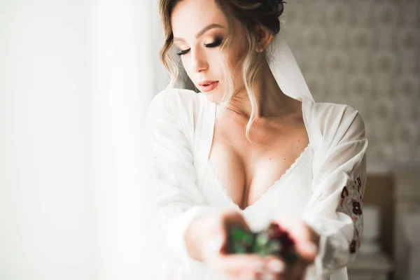 Mireasă superbă în halat pozând și pregătindu-se pentru fața ceremoniei de nuntă într-o cameră — Fotografie, imagine de stoc