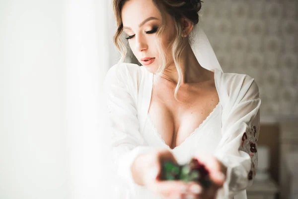 Gorgeous bride in robe posing and preparing for the wedding ceremony face in a room — Stock Photo, Image